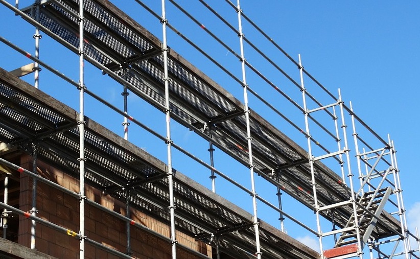 Baldadige jongens gooien steigeronderdelen van gebouw