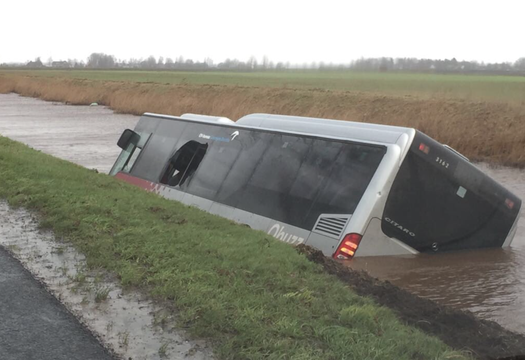 Bus waait met passagiers en al het water in
