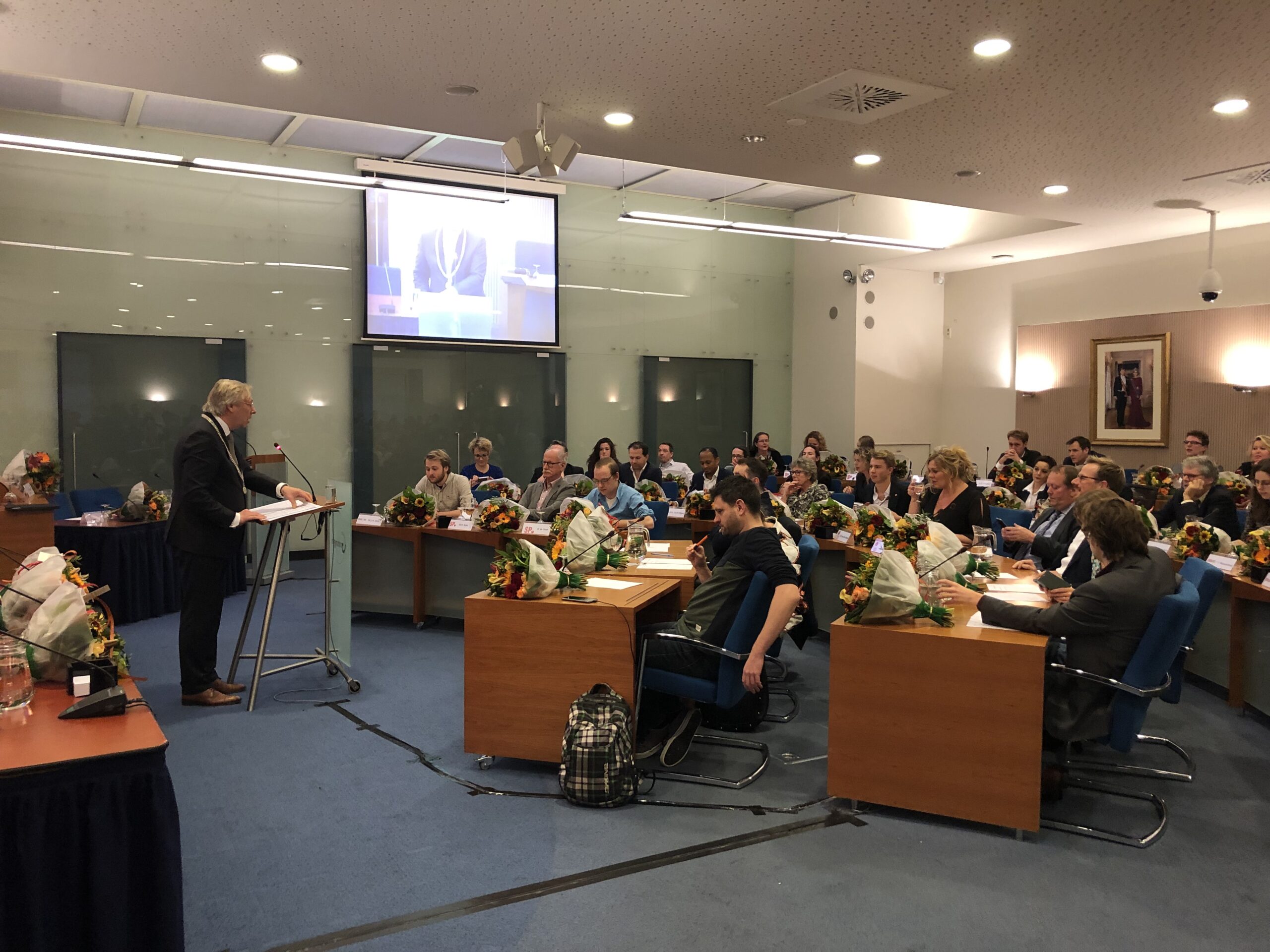 Burgemeester Peter den Oudsten geeft de nieuwe raadsleden tekst en uitleg, kort voor de installatie