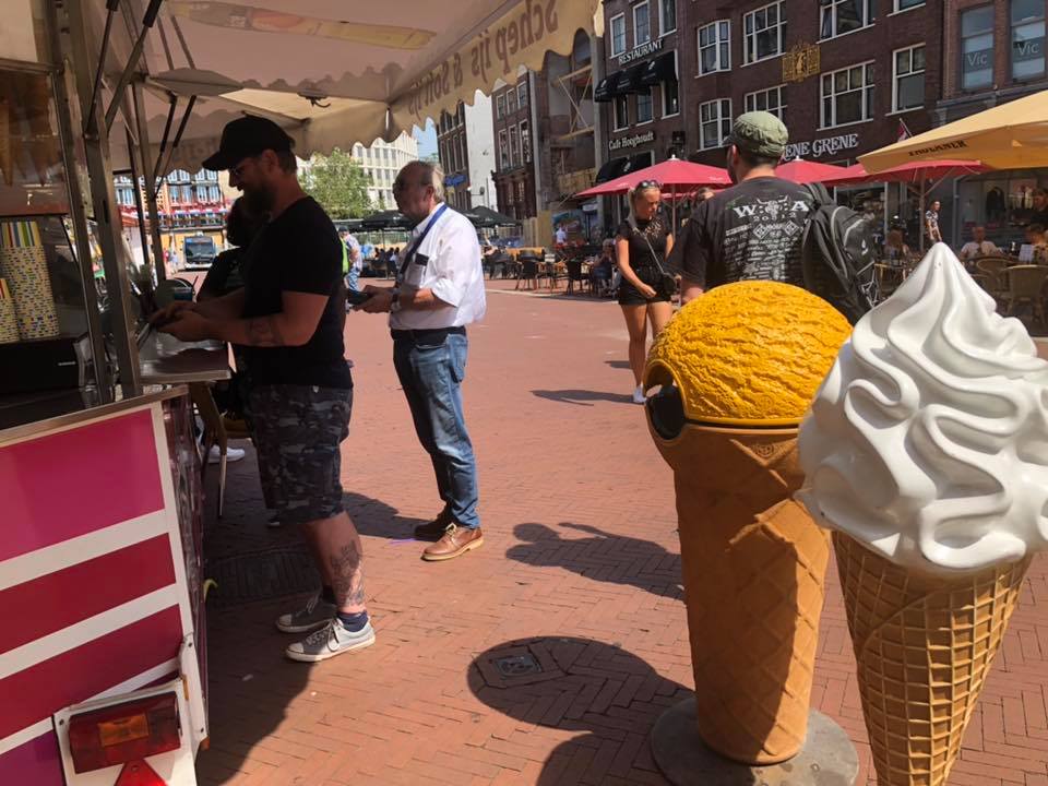 IJs eten op de Grote Markt. Vanwege het WK is één van de ijsjes oranje