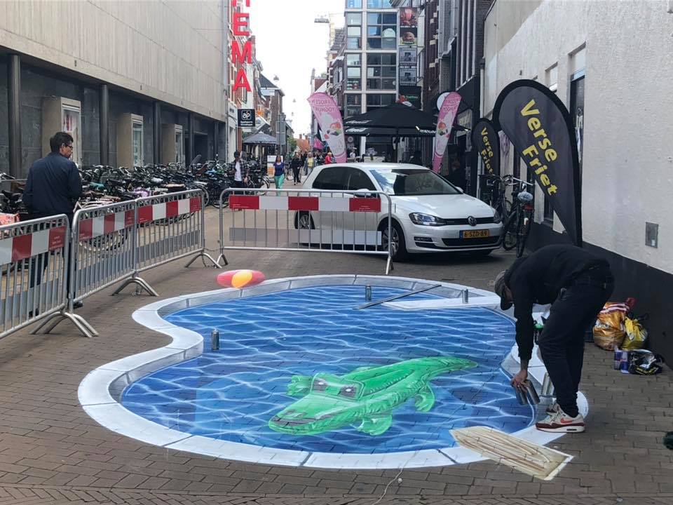 De kunstenaar legt de laatste hand aan het zwembad aan de Carolieweg
