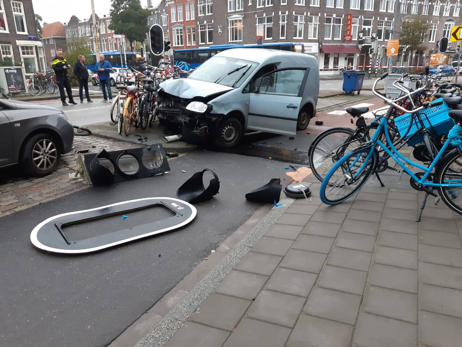 Automobilist ramt stoplicht en komt tot stilstand tegen fietsen