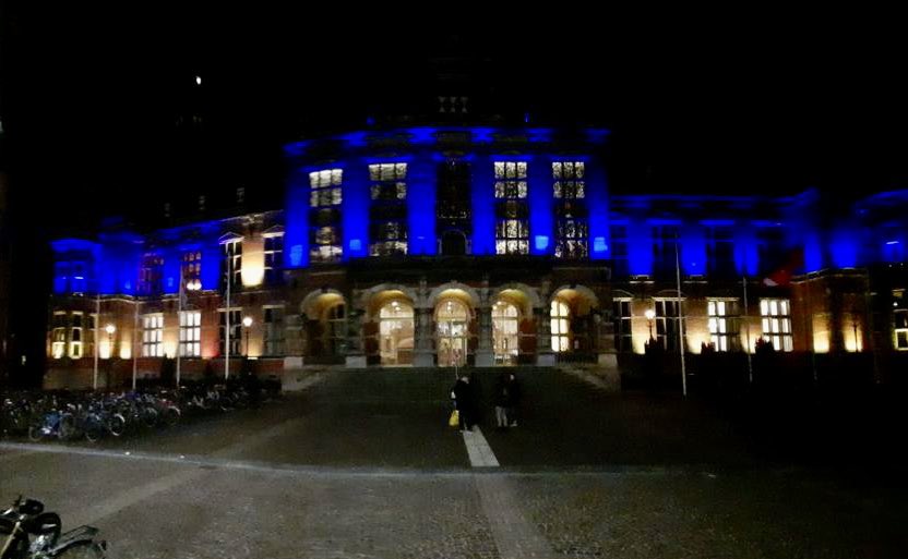Academiegebouw Groningen 's avonds verlicht in kleuren van de Oekraïense vlag