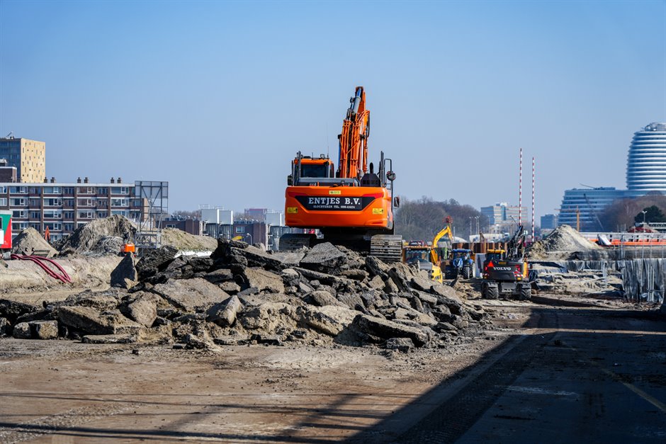 Het wegbreken van het asfalt, met op de achtergrond links de Julianafalt en rechts het gebouw van DUO/Belastingdienst. Foto: Raymond Bos.