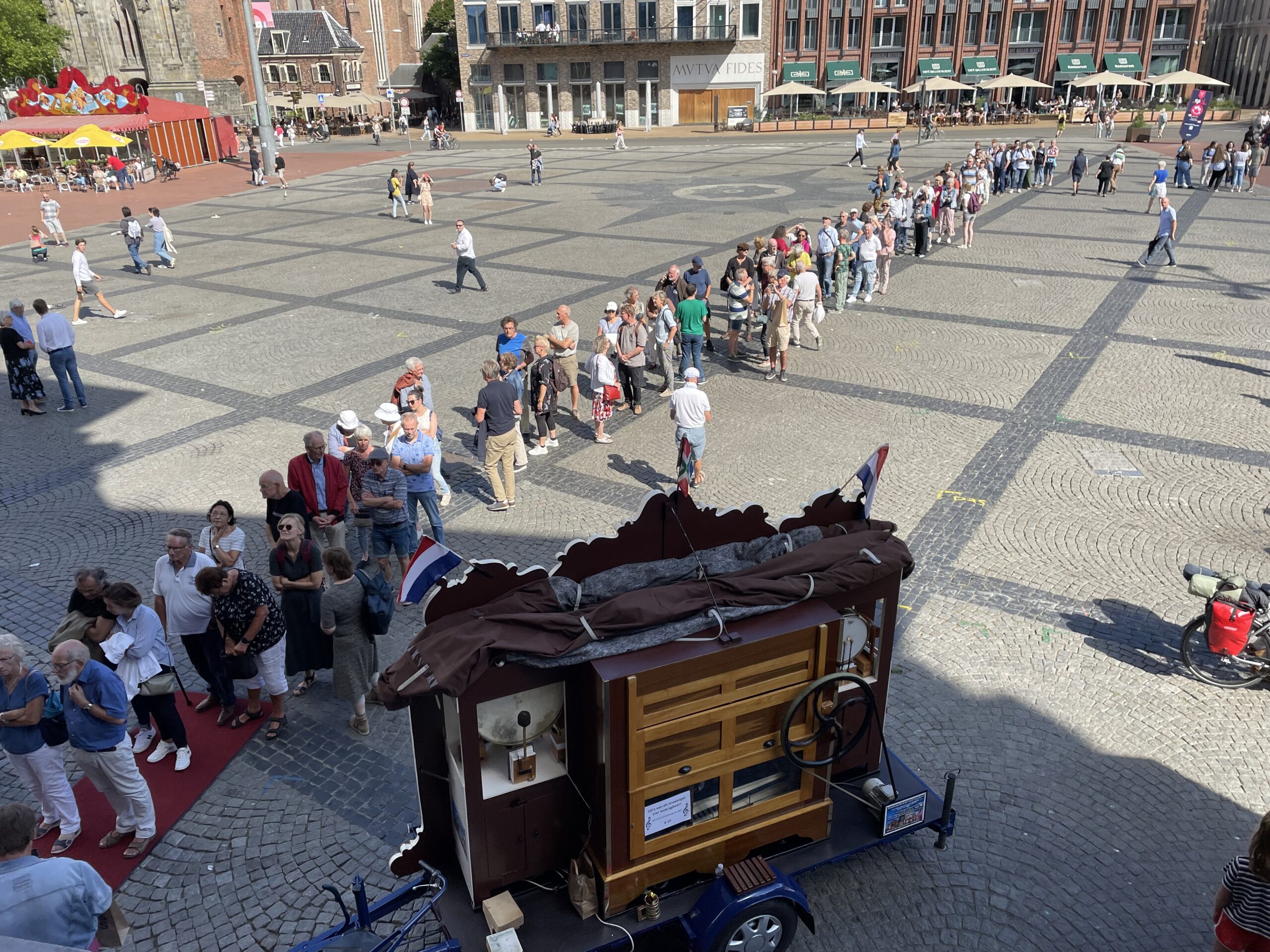 Lange rij wachtenden op Grote Markt in Groningen. Maar waarom staan ze in de rij?